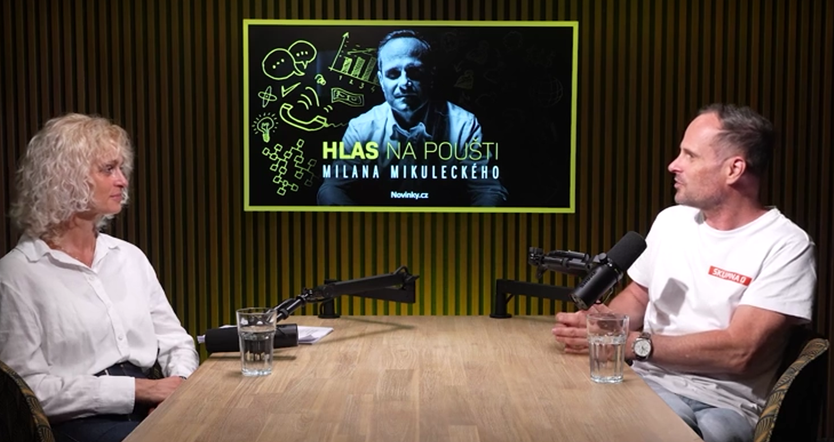 muž a žena sedí naproti sobě ve studiu u stolu